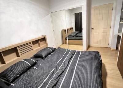 Modern bedroom with mirrored closet and wooden floor