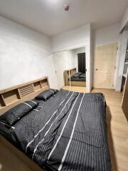 Modern bedroom with mirrored closet and wooden floor