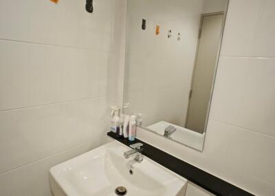 Modern bathroom with sink, mirror, and toiletries