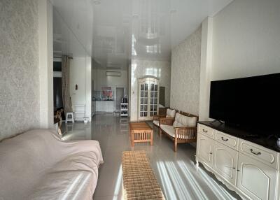 Spacious living room with modern decor and a view into the kitchen