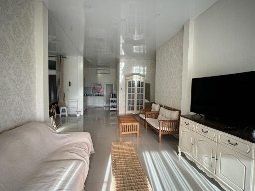 Spacious living room with modern decor and a view into the kitchen