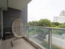 Spacious balcony with hanging chair and view of the city