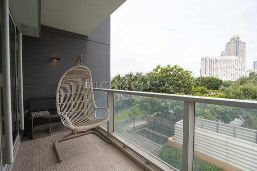 Spacious balcony with hanging chair and view of the city