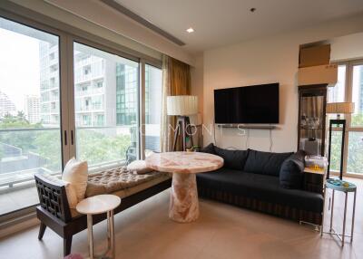 Modern living room with large windows, a sofa, and a small dining area