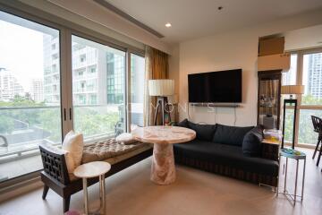 Modern living room with large windows, a sofa, and a small dining area