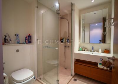 Modern bathroom with glass shower enclosure and wooden vanity