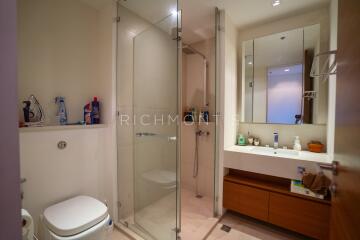 Modern bathroom with glass shower enclosure and wooden vanity