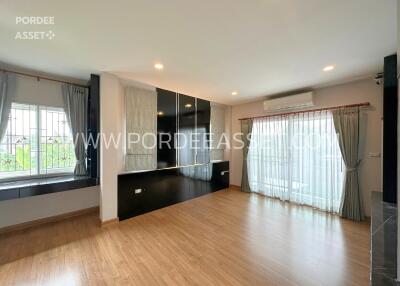 Spacious living room with wooden flooring and large windows