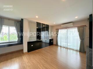 Spacious living room with wooden flooring and large windows