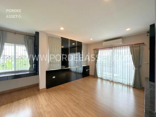 Spacious living room with wooden flooring and large windows