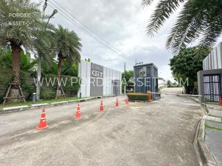 Gated community entrance with security gate and traffic cones