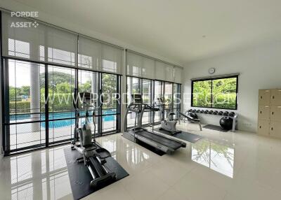 Modern gym with large windows overlooking a pool