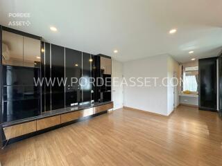 Spacious living room with wooden flooring and built-in storage