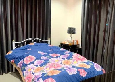 Bedroom with floral bedding and dark curtains