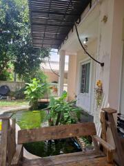 Outdoor sitting area with a view of a garden and fish pond