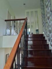 Interior staircase with dark wooden steps and modern railing