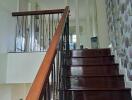 Interior staircase with dark wooden steps and modern railing