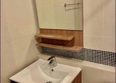 Modern bathroom with sink, mirror, and partial view of toilet