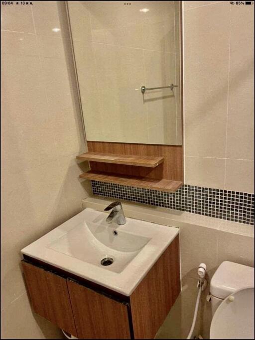 Modern bathroom with sink, mirror, and partial view of toilet