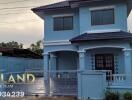 Two-story blue house with a fenced yard