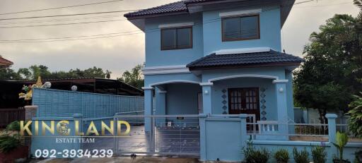 Two-story blue house with a fenced yard