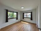 spacious bedroom with wooden floor and large windows