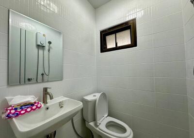 Modern bathroom with toilet, sink, mirror, and shower