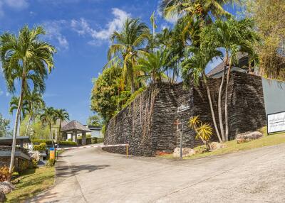 Driveway with lush greenery and modern stone wall