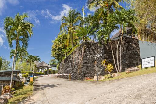 Driveway with lush greenery and modern stone wall