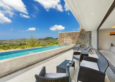 Outdoor area with swimming pool and lounge chairs, overlooking scenic hills