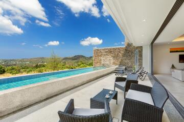 Outdoor area with swimming pool and lounge chairs, overlooking scenic hills