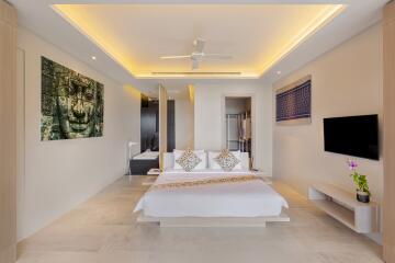 Spacious modern bedroom with ceiling fan, artwork, mounted TV, and minimalist decor