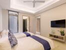 Modern bedroom with two single beds, ceiling fan, and a wall-mounted TV