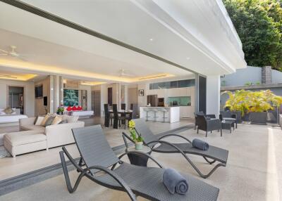 Spacious and luxurious outdoor living area with lounge chairs and shaded seating.