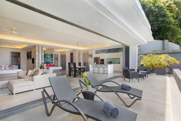 Spacious and luxurious outdoor living area with lounge chairs and shaded seating.