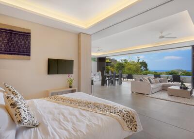 Spacious open-plan living area with bedroom, lounge, dining area, and ocean view.