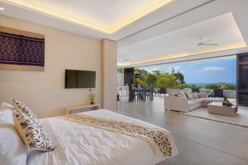 Spacious open-plan living area with bedroom, lounge, dining area, and ocean view.