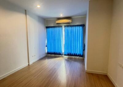 Empty room with wooden flooring and blue curtains