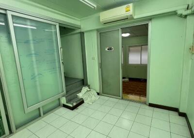 Small room with tiled floor, fluorescent lights, and glass door