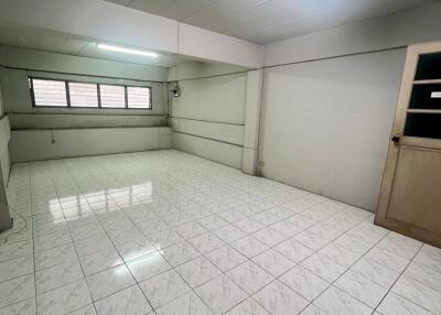 Empty room with tiled flooring and fluorescent lighting