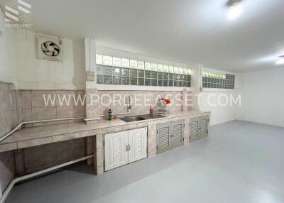 Modern kitchen with tiled backsplash, stainless steel sink, and ventilation fan