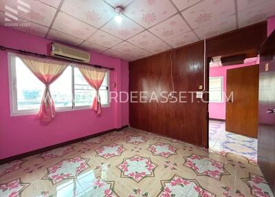 Bright bedroom with pink walls, floral tile flooring, and air conditioning