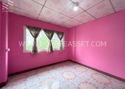 Pink bedroom with floral ceiling tiles and curtains