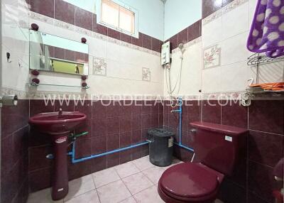 Bathroom with burgundy fixtures and tiled walls