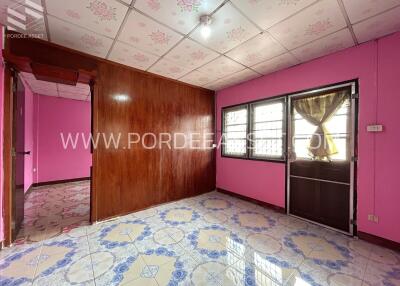 Main living area with pink walls, tiled floor, and large window