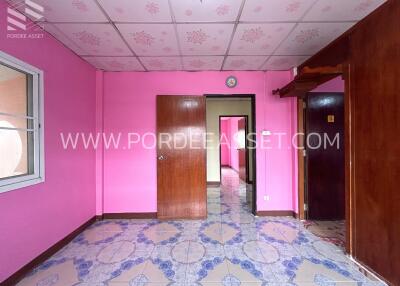 Bright pink bedroom with wooden doors and patterned tile floor