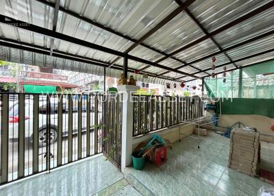 Covered outdoor area with railing and parked car view