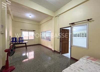 Spacious main living area with windows and basic furniture