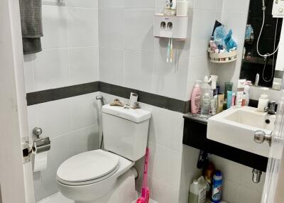 Clean and modern bathroom with white tiles and essential amenities