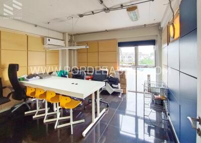 Modern office workspace with chairs, desks, and a large window.